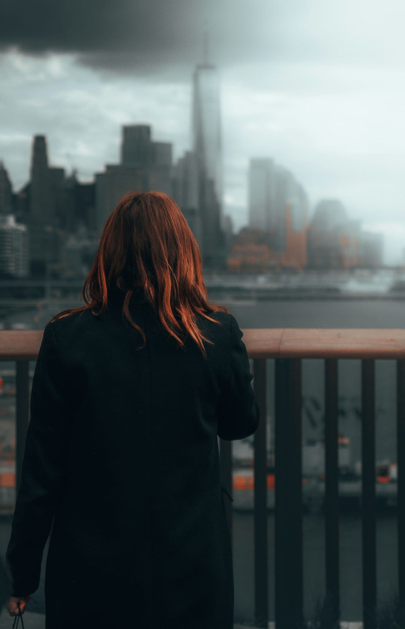 A woman on a balcony looking out over the city